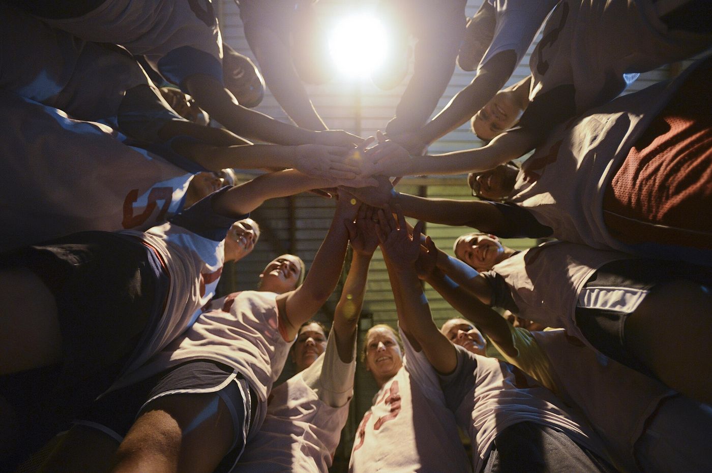 A team stacks hands in a huddle