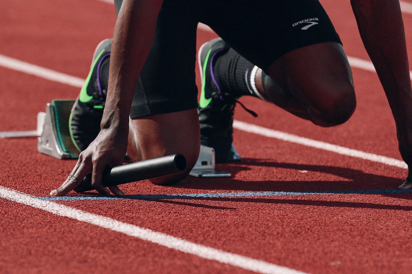 A sprinter's hands set behind the start line