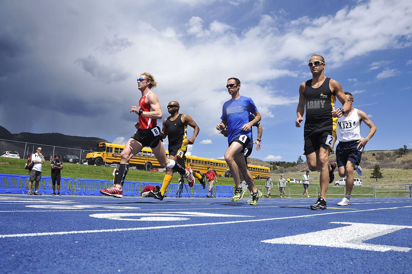 Distance runners round the turn on a blue track
