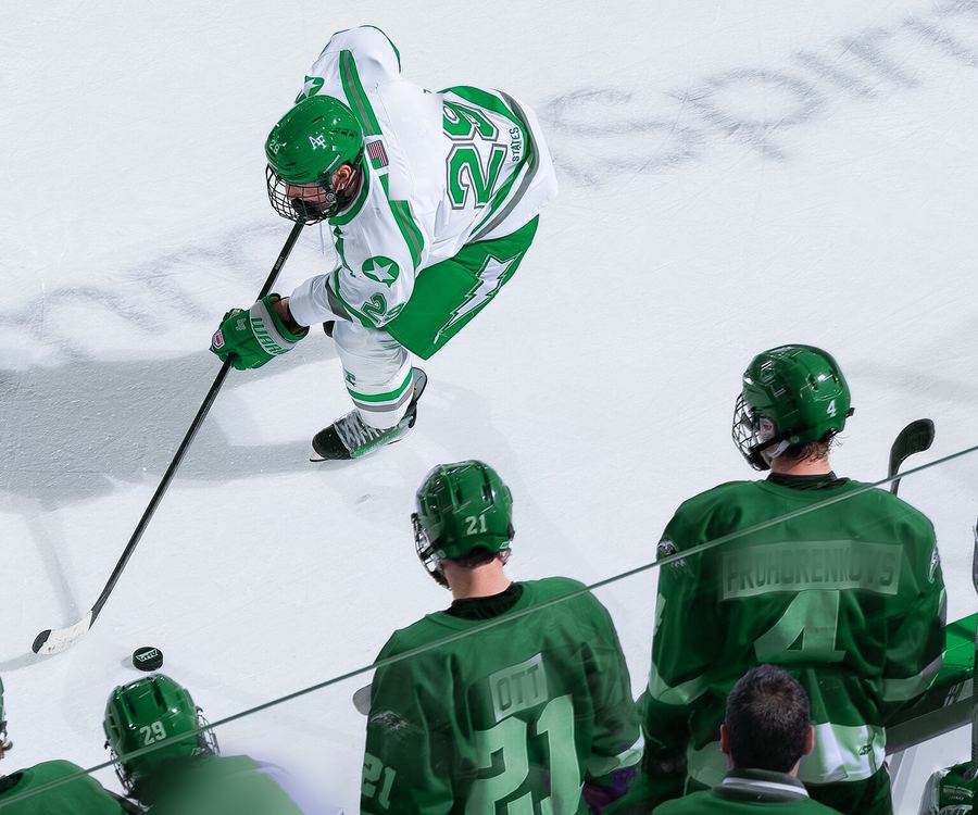A Timberwolves skater handles the puck past the bench