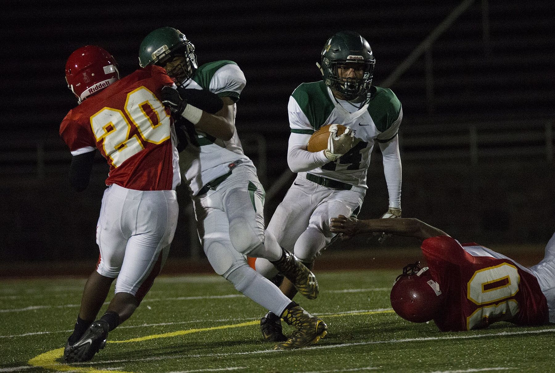 Panthers defenders close in on a ball carrier under the lights